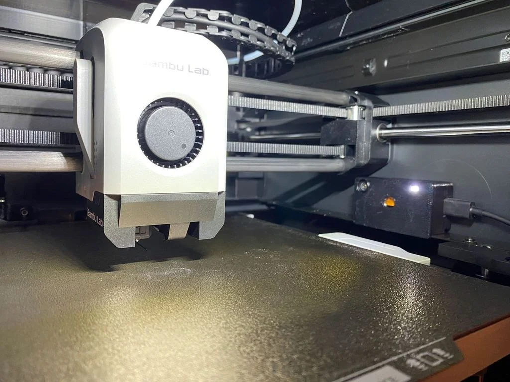 Druckkopf eines Bambu Lab P1S über der Bauplatte, von der Seite
